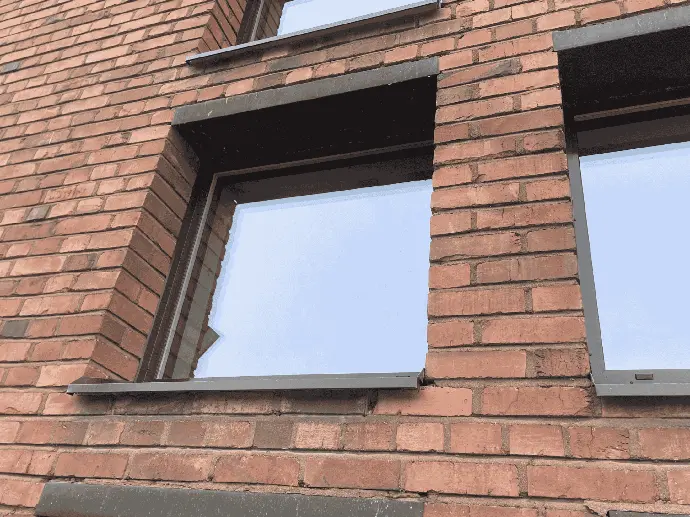 Tiiliverhoiltu rakennus, jossa on säännöllinen ikkunarivi.