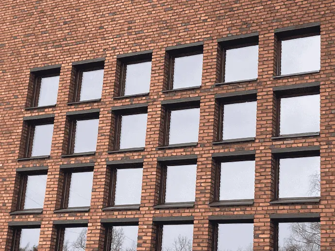 Tiiliverhoiltu rakennus, jossa on säännöllinen ikkunarivi.