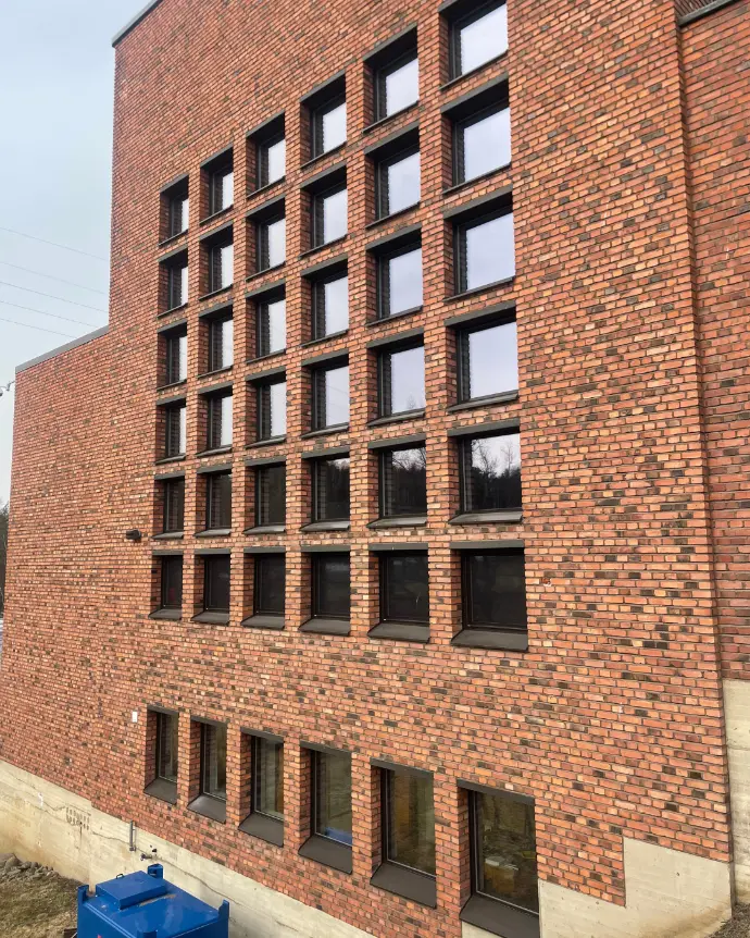  Tiiliseinä, johon on asennettu ikkunoita useisiin kerroksiin.