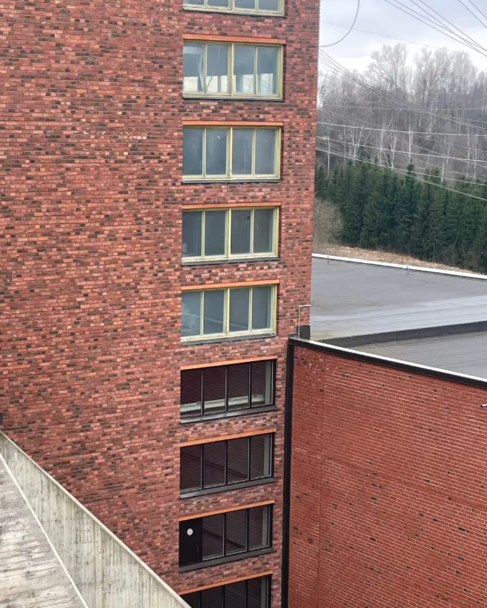  Tiiliseinä, johon on asennettu ikkunoita useisiin kerroksiin.